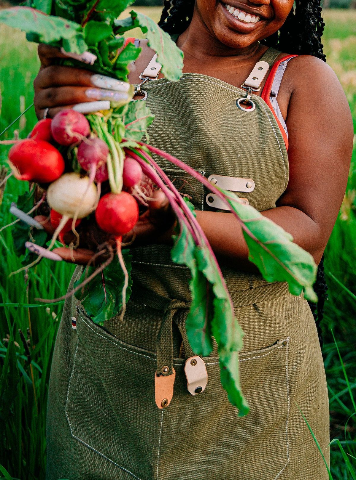 Person holding fresh radishes in an apron